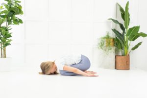 A yoga instructor demonstrating child's pose