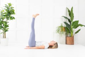 A yoga instructor demonstrating legs up on wall pose
