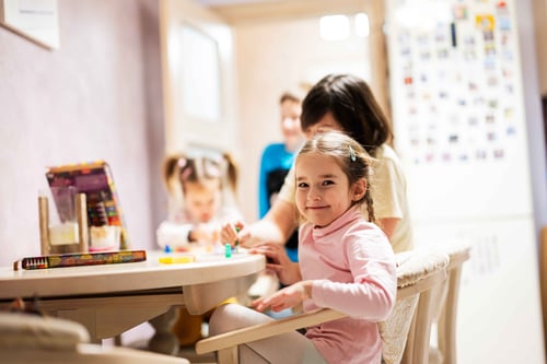 types of daycare a kid smiling at the childcare 