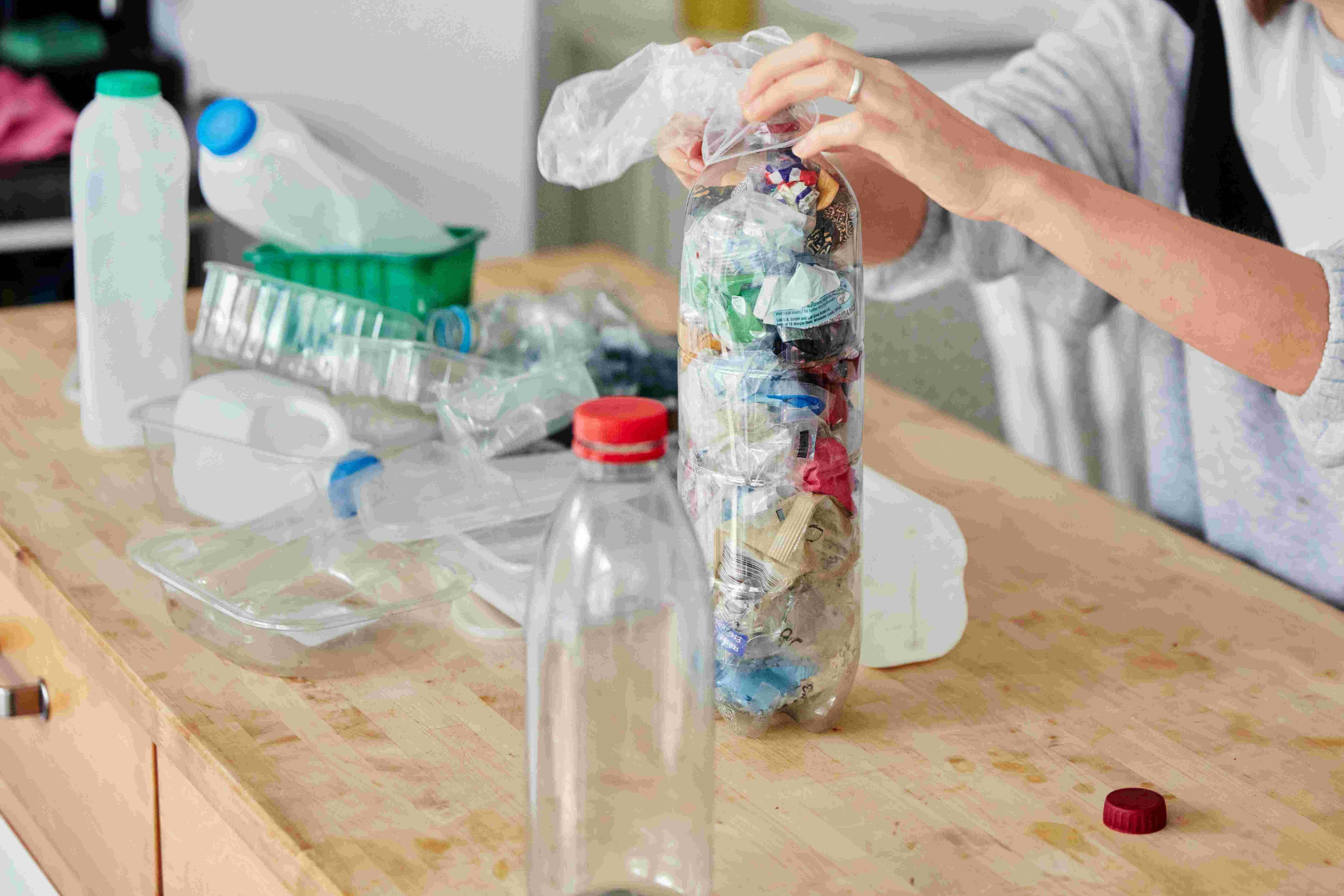 woman-stuffing-soft-waste-plastics-into-large-plas-2026-03-25-06-32-38-utc