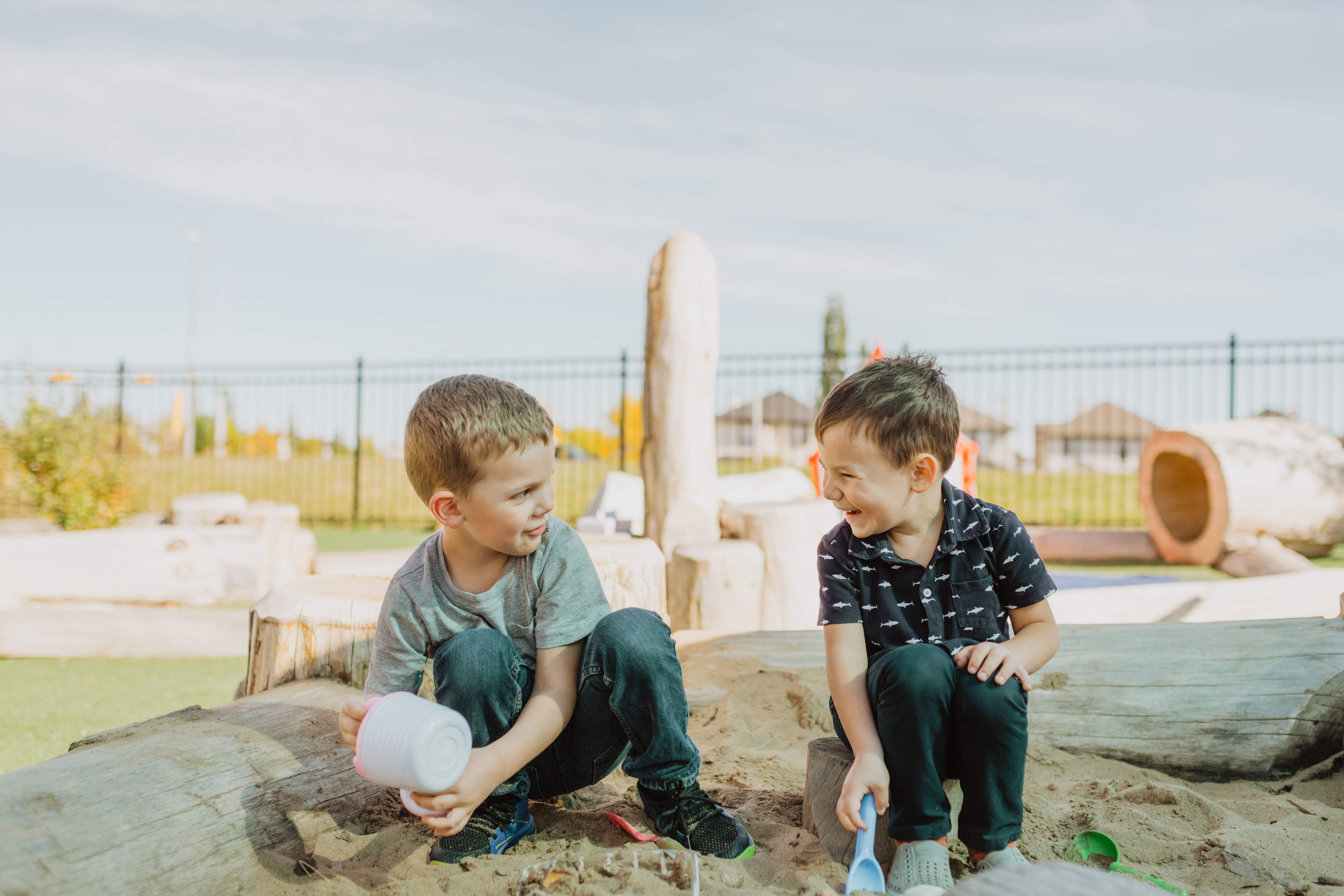 Two young boys playing in a sandbox together at a BrightPath daycare centre. 