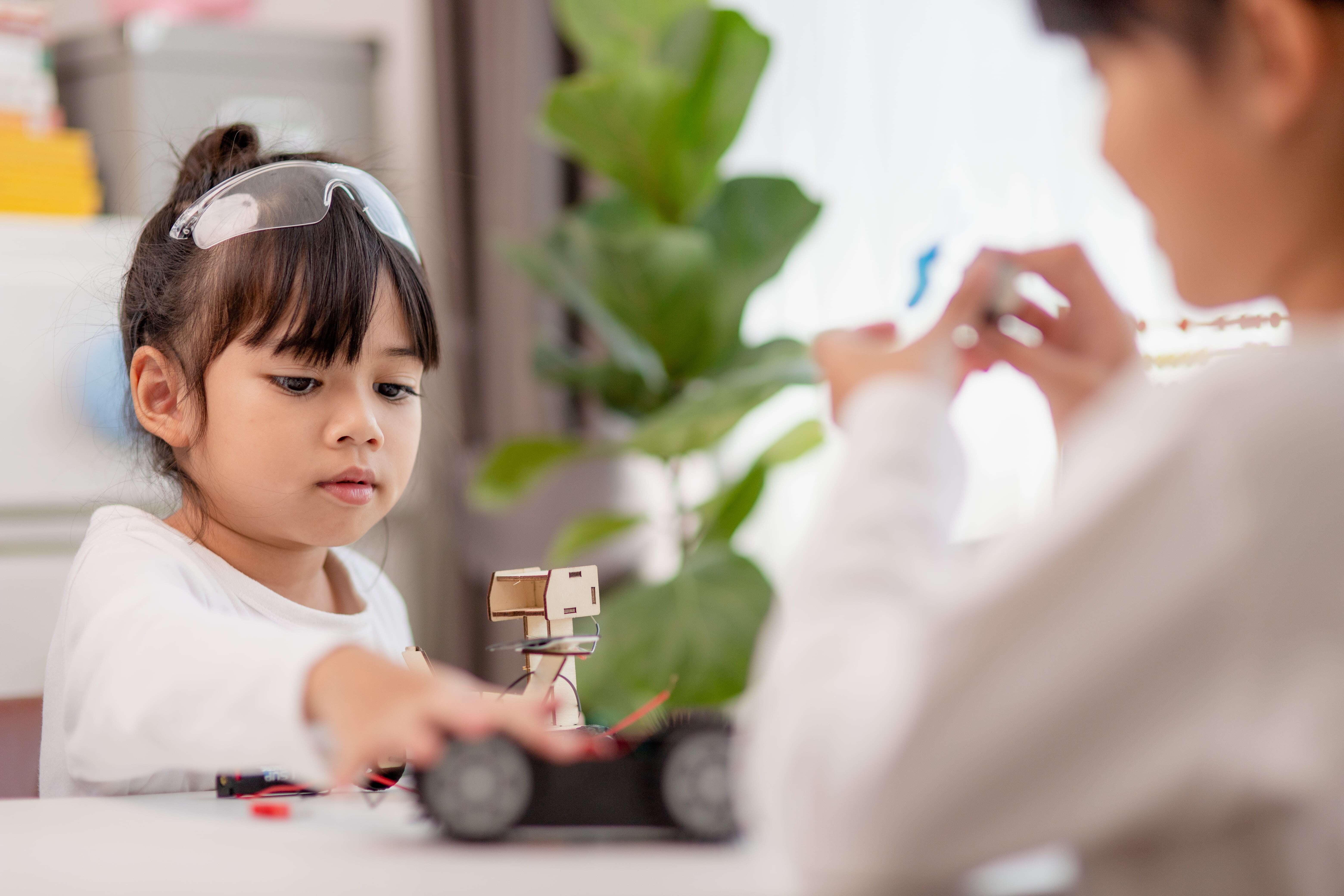 A young female child working with her educator to explore STEM in Early Childhood Education.