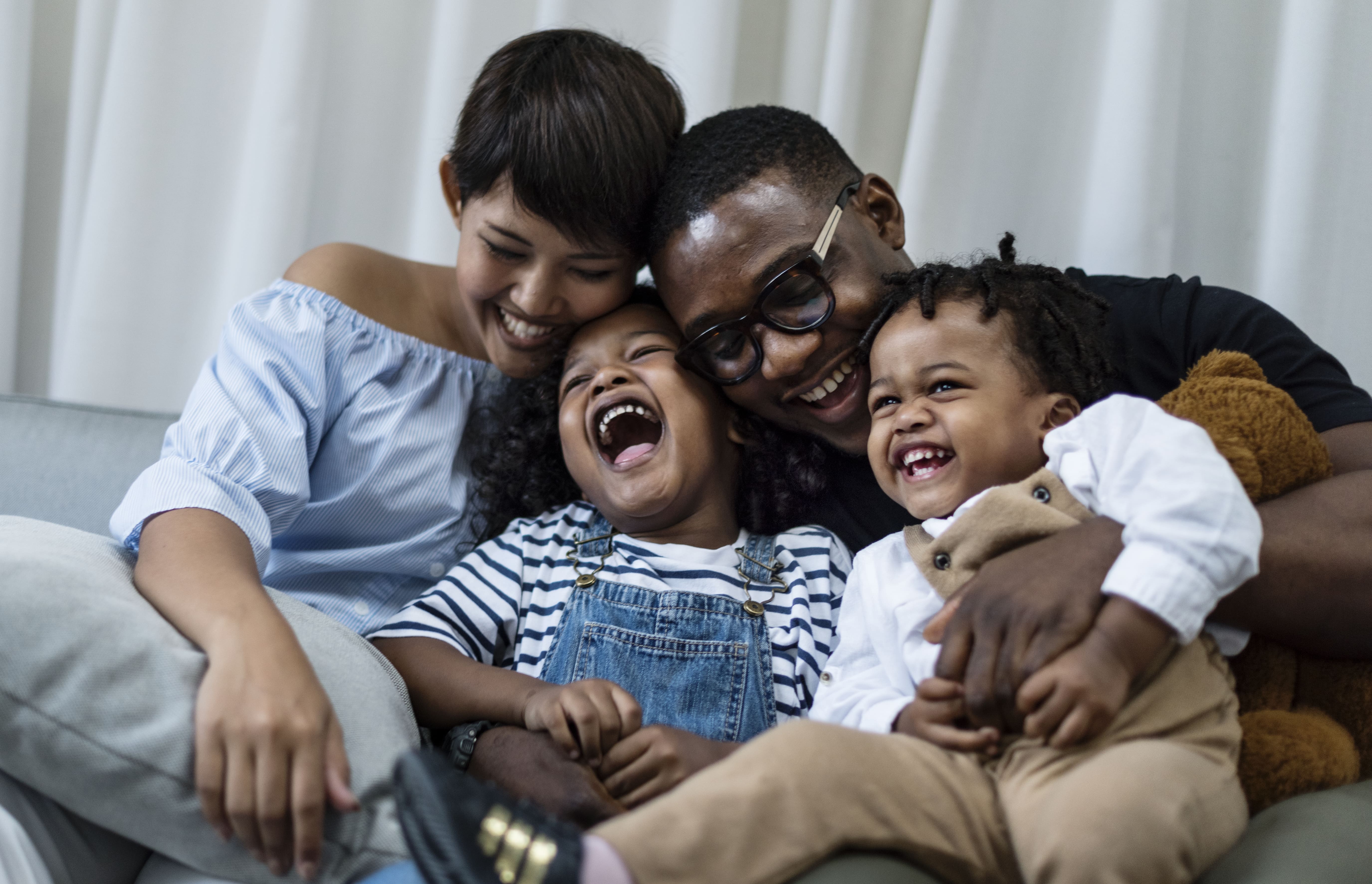 A young family hugging and laughing together.