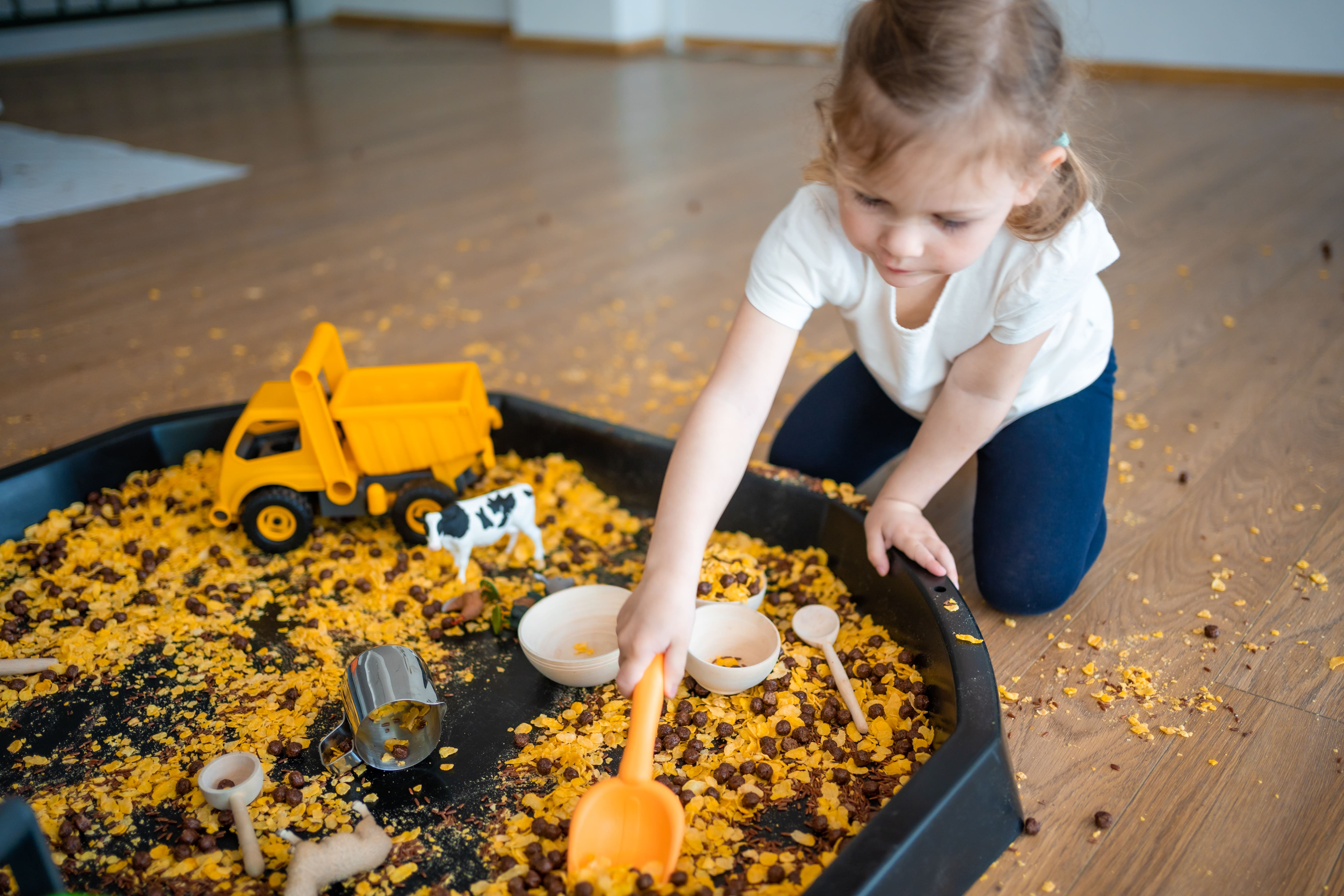 A young girl exploring a fall-themed sensory bin.