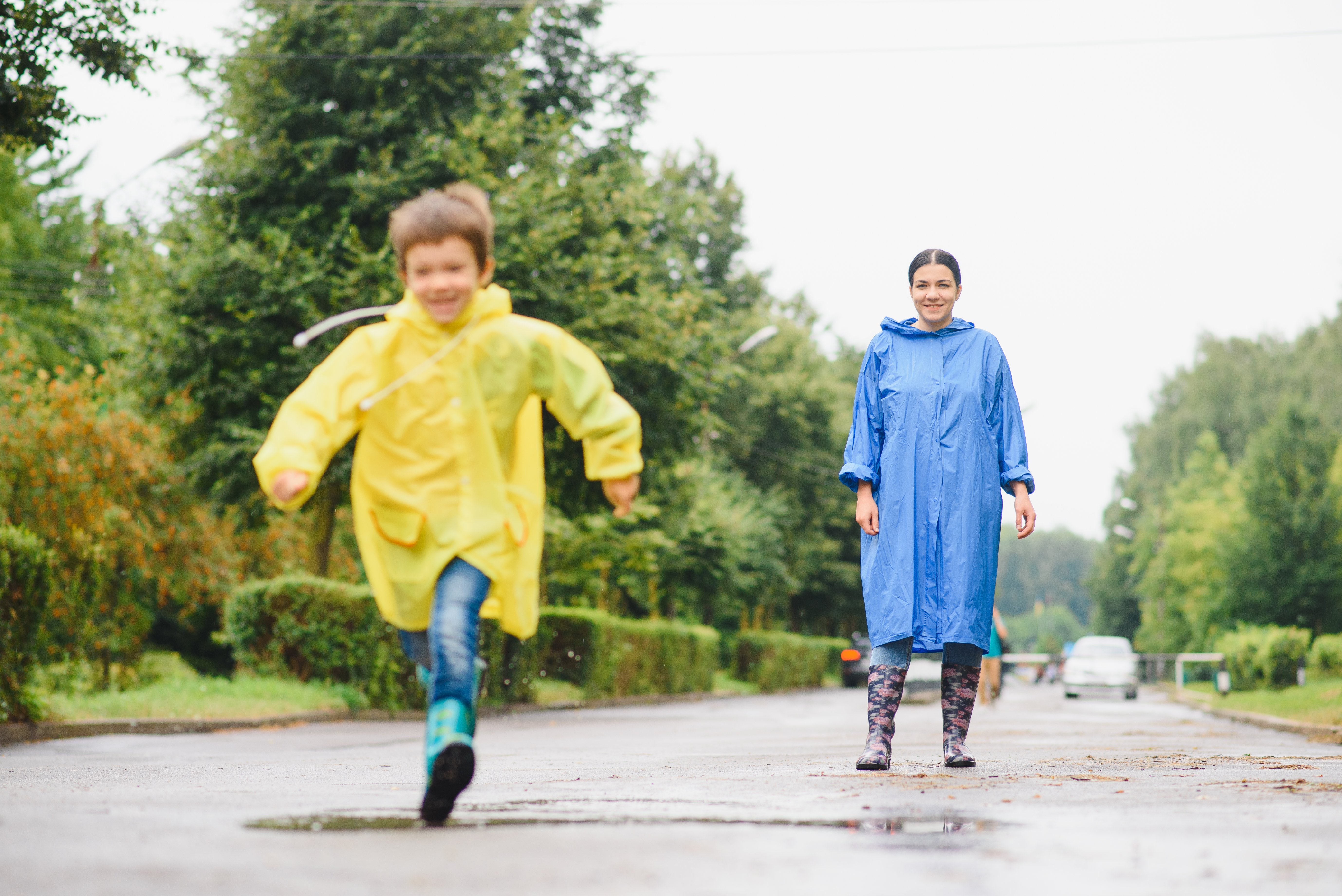 kid and mom playing outside in the rain together
