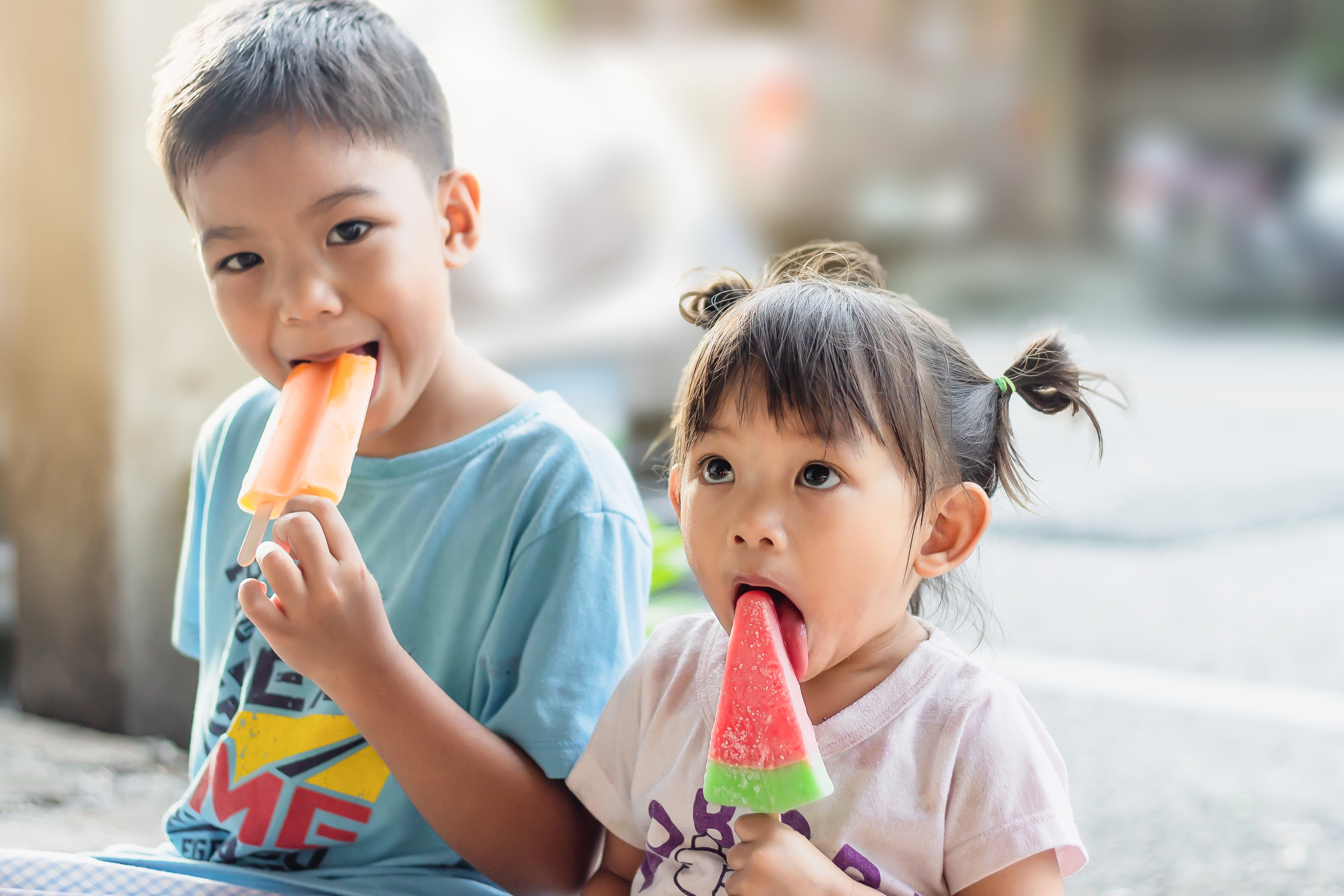 two kids enjoying cold treats together