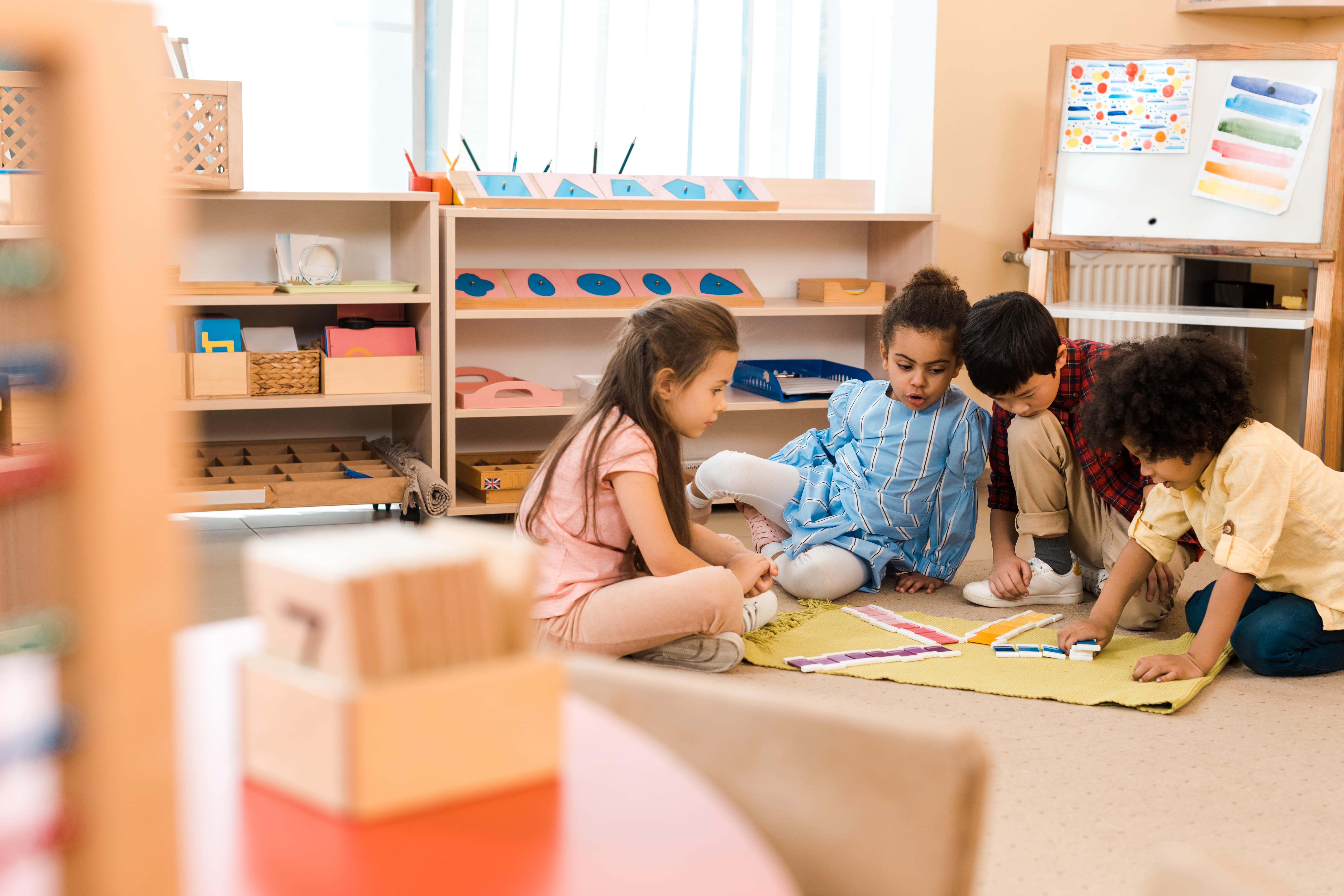 Four children in a preschool classroom playing together. 